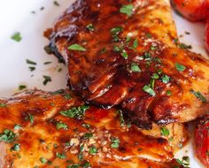 two pieces of meat on a plate with tomatoes