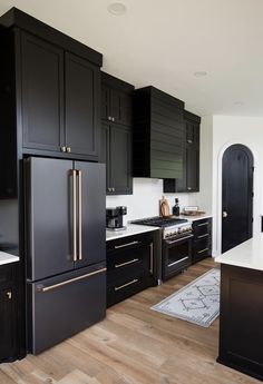 a kitchen with black cabinets and gold trimmings on the doors, stove top oven, refrigerator and microwave