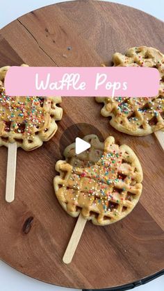 three waffle pops with sprinkles on them sitting on a wooden board