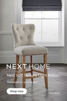 an upholstered bar stool in front of a window with roman shades on it