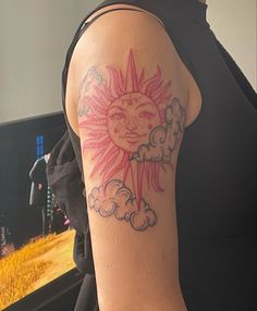 a person with a sun and clouds tattoo on their arm