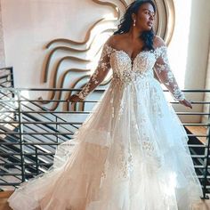 a woman in a wedding dress standing on stairs