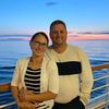 a man and woman are standing on the deck of a cruise ship