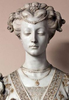 a statue of a woman with pearls on her head