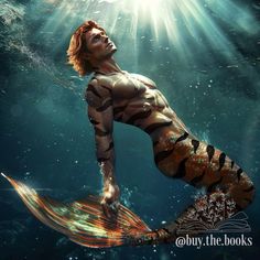 a man is swimming in the water with his body painted like a tiger stripe mermaid