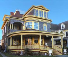 a large yellow house with many windows and balconies on the second floor is shown