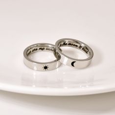 two wedding rings on a white plate with the words i love you to the moon and back