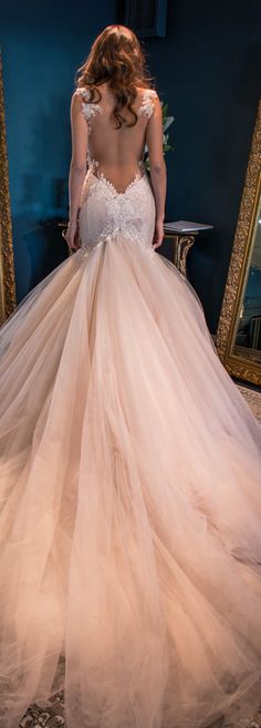 the back of a wedding dress with an open back and lace appliques on it