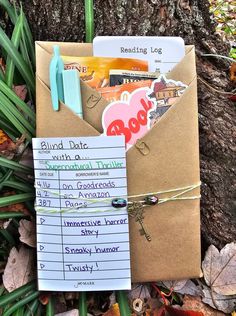 a brown envelope with some stickers on it sitting in the grass next to a tree