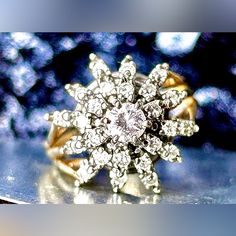 a diamond ring sitting on top of a table next to a blue and white background