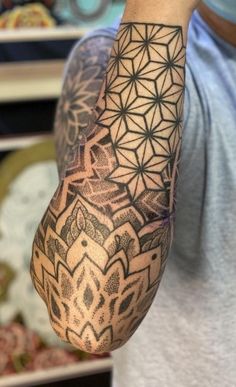 a man's arm with an intricate tattoo design on the left side of his arm