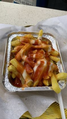 french fries covered in ketchup and mayonnaise on a tray