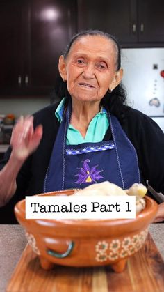 an old woman is standing in front of a bowl with food on it and the words tamales part 1