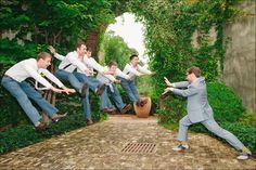 a group of men in suits jumping up into the air