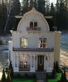 a doll house is shown in front of some trees