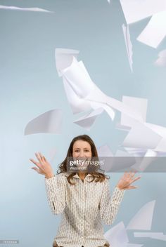 a woman with her hands in the air and flying papers behind her stock - fotor