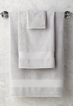 two white towels are hanging on the wall