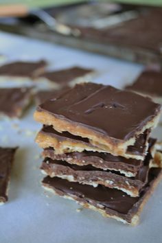 there are many pieces of chocolate and peanut butter bars on the plate, stacked together