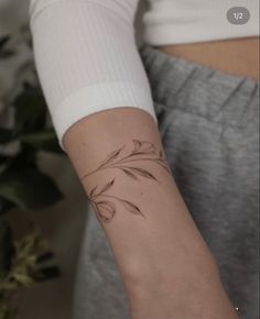 a woman's arm with a flower tattoo on the left side of her arm