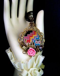 a close up of a person's hand wearing a bracelet with flowers on it