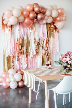 a table with some balloons and flowers on it