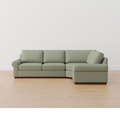 a couch sitting on top of a hard wood floor next to a white wall in an empty room