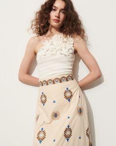 This soft a-line skirt is intricately embroidered in bold blue, rich tan, and soft sand coloring detailing a floral-inspired motif. Complement the high-rise waist with the matching top or a flowy t-shirt. Side-zip closure Length from Highest Point to Hem: 36 1/2" Detailed embroidery throughout Side slits Cotton Poplin Spring Embroidered Beige Skirt, Fitted Floral Embroidered Skirt, Chic Fitted Skirt With Floral Embroidery, Elegant Floral Skirt For Spring, Elegant Floral Embellished Skirt For Spring, Spring Beige Flared Skirt Dress, Spring Beige Dresses With Flared Skirt, Summer Cream Embroidered Skirt, Spring Floral Embroidered Flared Skirt Dress