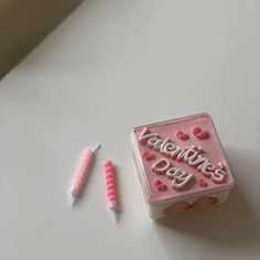 a valentine's day cake next to two toothbrushes on a white surface