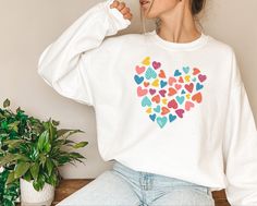 "Cute Heart Sweatshirt Sweater, Gift For Valentine's Day, Birthday Shirt For Wife, Sweet Shirt For Couple, Happy Valentine's Day Shirt PLEASE READ: ❧ Please note that these sweatshirts are unisex size meaning they are not women's fitted shirts. With unisex sizing, these are great for both men and women. For men, order true to size. For women, order true to size or size down by 1 for a more fitted look. ❧ If you are unsure about the size you should order, please refer to the size chart in the pic Kisses Shirt, Valentines Day Sweatshirt, Cute Valentines Day, Valentines Day Heart, Fitted Shirts, Cute Valentines, Sweet Shirt, Heart Sweatshirt, Sweater Gift