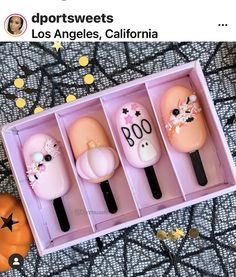 three different items in a pink box on a table with pumpkins and other decorations