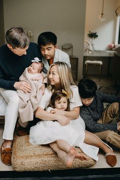 a family is sitting on the floor together