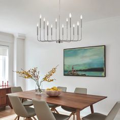 a dining room table with chairs and a bowl of fruit on it