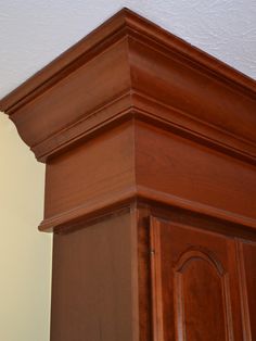 the corner of a wooden cabinet with white paint on it's walls and ceiling