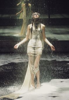 a woman is standing in the rain with her arms spread out to show off her body