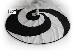 a round black and white floor mat with a tree in it's center on a white background