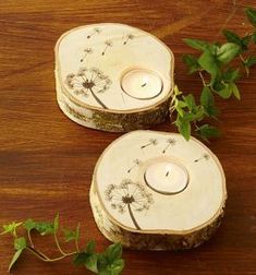 two wooden candlesticks with dandelions on them sitting on top of a table