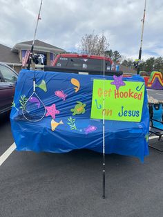 a blue covered table with fish on it in a parking lot