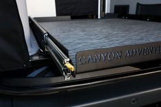 the back end of a black car with canyon adventure written on it