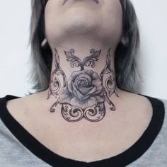 a woman with a black and white rose tattoo on her neck is looking up at the sky