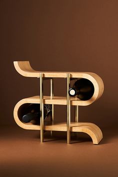 a wooden shelf with two wine bottles on it and a bottle holder in the middle