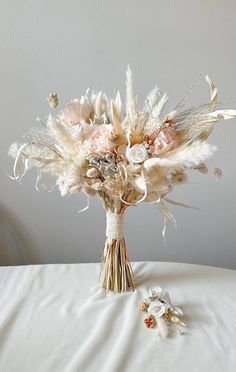 a bridal bouquet with dried flowers and feathers