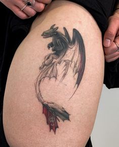 a woman's thigh with a dragon tattoo on it