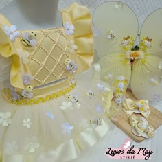 a dress made out of yellow and white material with flowers on the bottom, along with other accessories