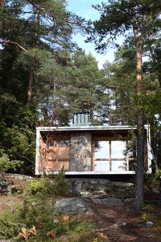 a small cabin in the woods surrounded by trees