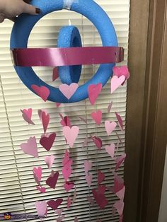 someone is decorating a door with pink and blue paper hearts