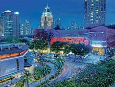 the city is lit up at night with skyscrapers in the background