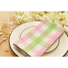 a pink and green checkered napkin sitting on top of a white plate