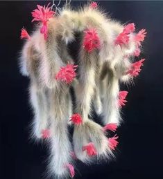 pink flowers are attached to the back of an animal's fur hanging ornament