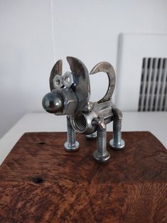 a metal dog sculpture sitting on top of a wooden table