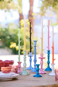 there are many different colored candles on the table